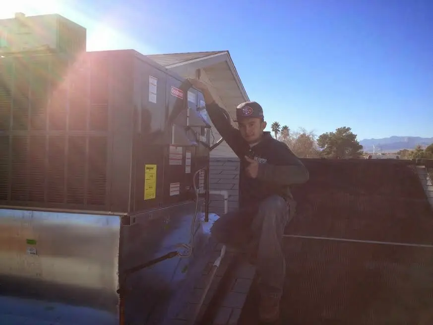 HVAC technician performing AC Tune-Up on a rooftop unit in Monterey